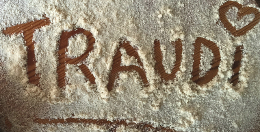 Eine Säge neben vielen Sägespänen, in die das Wort Traudi geschrieben wurde.